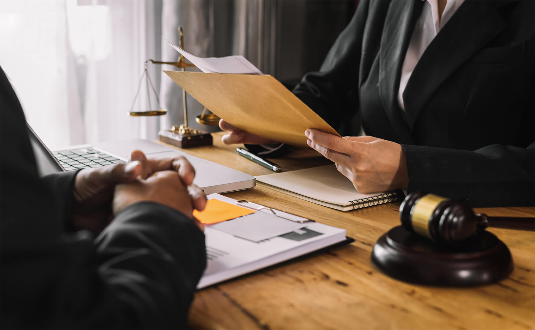 Client and attorney interaction at office desk.