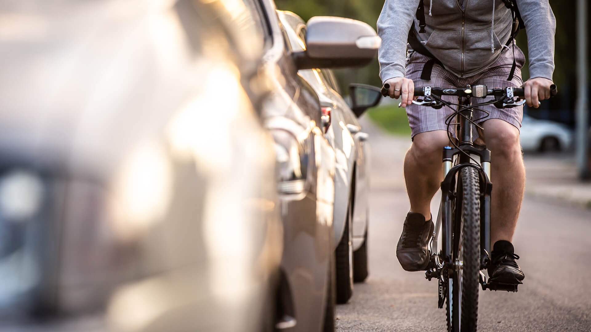 Ciclista montando cerca de autos estacionados - California AB 1902 - Medidas de seguridad mejoradas para ciclistas